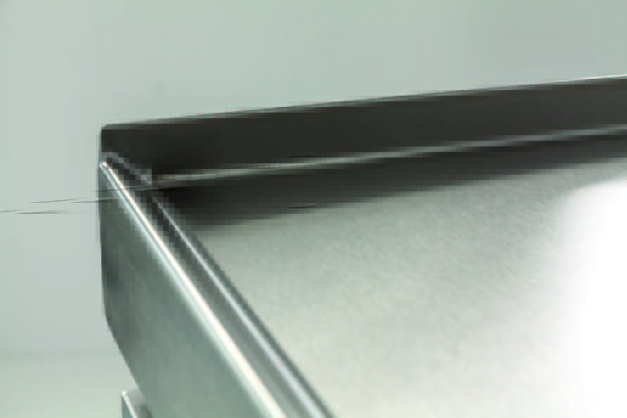 A close-up view of the seamless, easy-to-clean stainless steel top surface and edge of a piece of Hoshizaki commercial refrigeration equipment