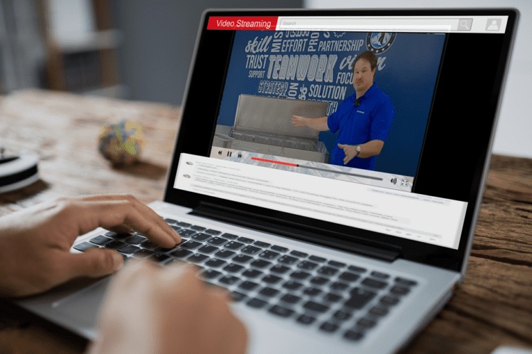 A technician watches a Hoshizaki service and training video on a laptop screen, utilizing virtual support resources